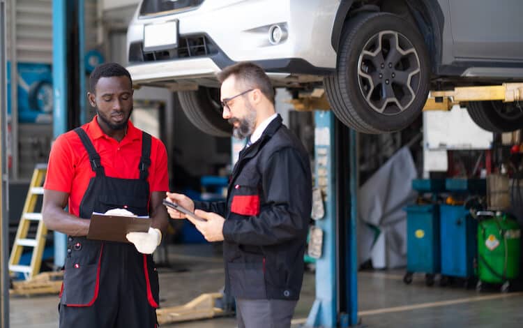 Car insurance and non life insurance concept. Insurance assessor and mechanic car repair man examine to the car damage.